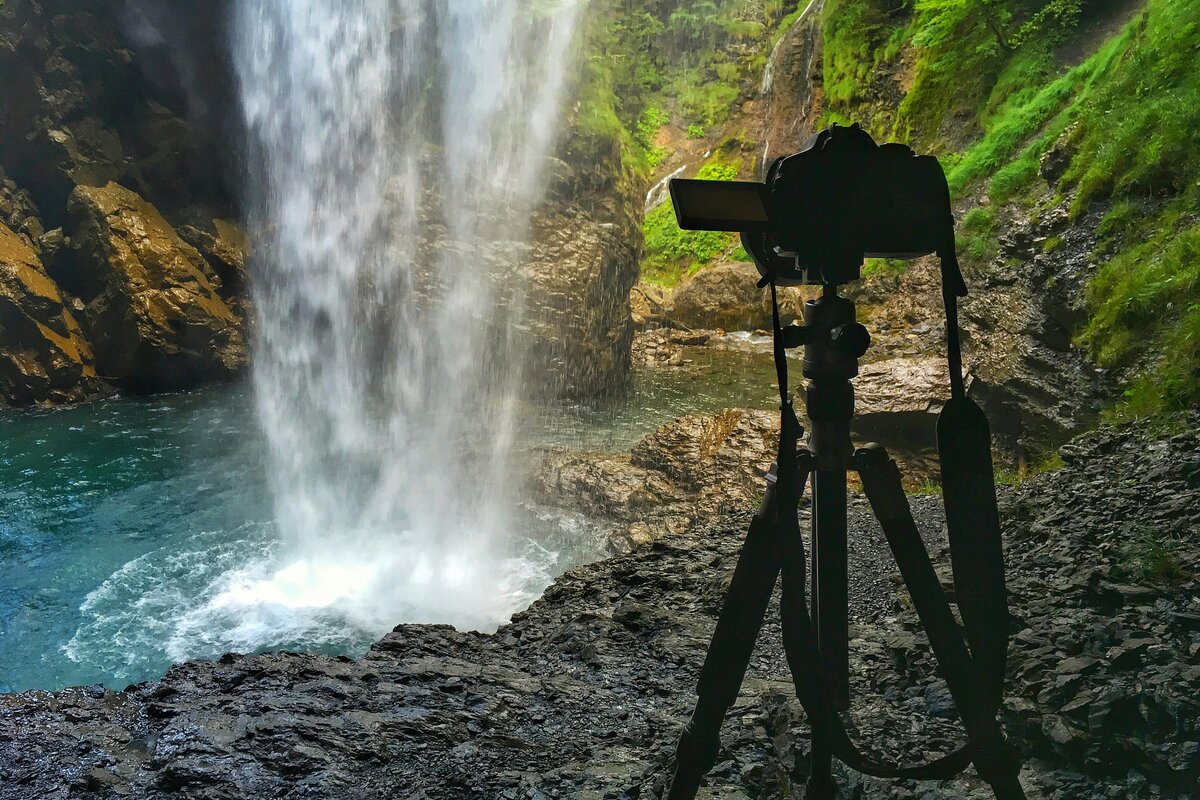 Kamera jalustalla suunnattu järvimaisemaan aamusumussa